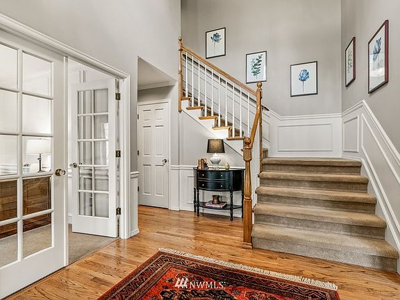  2 story foyer with wainscoting and contemporary chandelier.