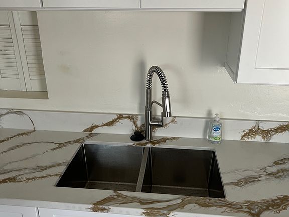 New kitchen sink and countertops. Passthrough window leads into dining room.