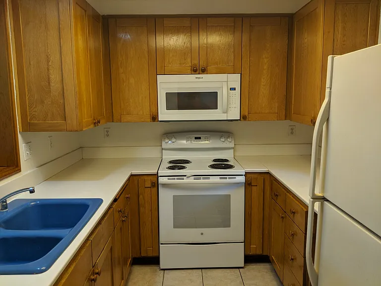 Kitchen includes stove/oven, microwave, refrigerator, dishwasher, & garbage disposal. Corian countertops.