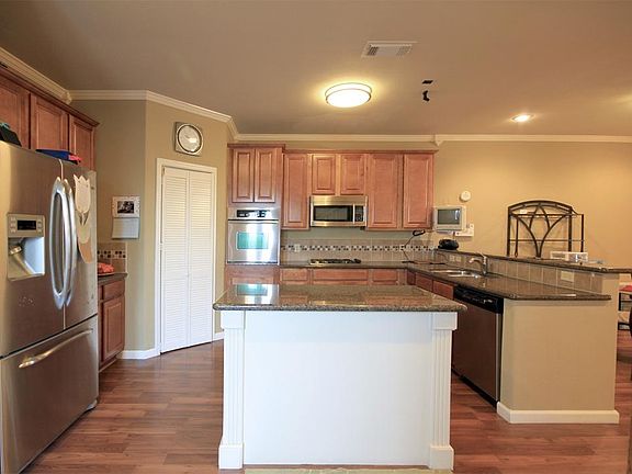 Center island kitchen with stainless steel appliances and a breakfast bar.