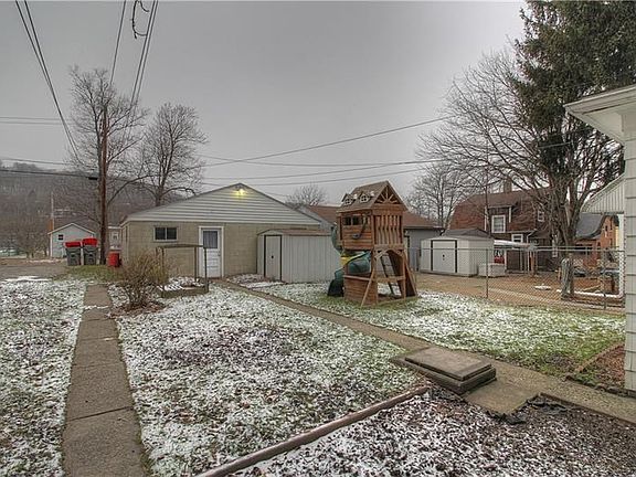 Ample back yard features a detached, oversized two-stall garage, shed and alley access. Concrete sidewalks and drive to garage.