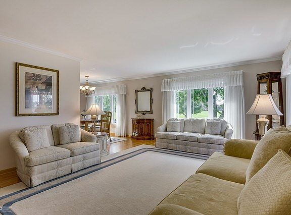 Up a few stairs to the sun-drenched living room accented by crown molding, oak railings and newer prairie-style windows