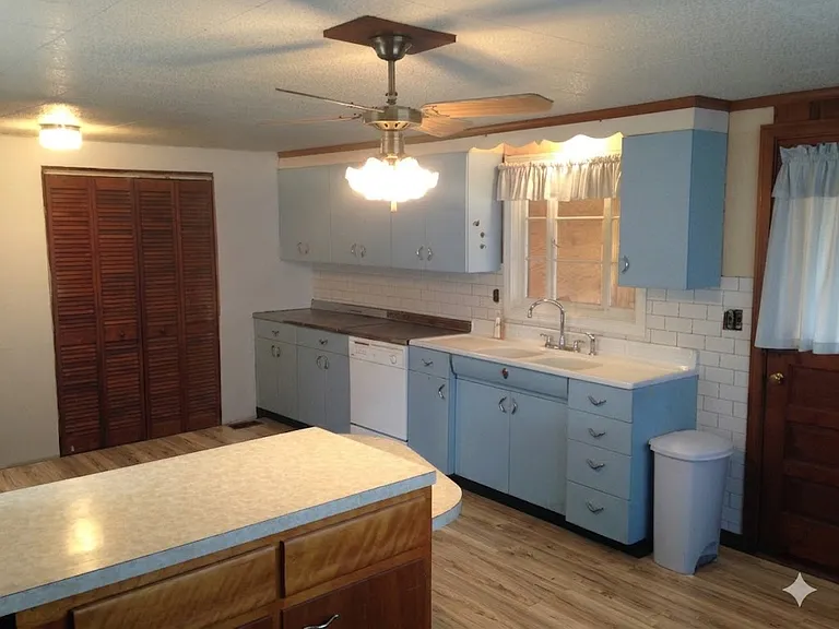 The highlight of this darling home is the Mid Century Modern kitchen! There is a double door pantry, a breakfast bar island, new vinyl plank flooring, door to the 3-season room, large window overlooking the green yard space.