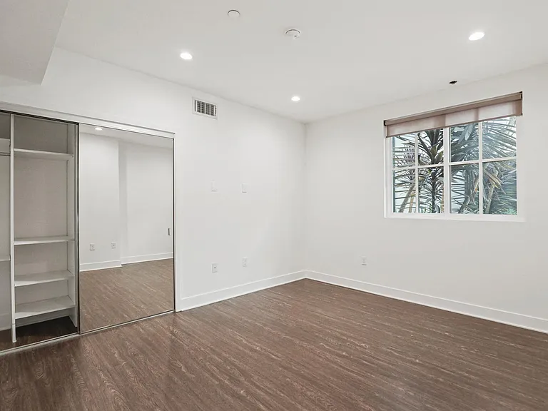 Bedroom with Mirrored Closet and Vinyl Flooring