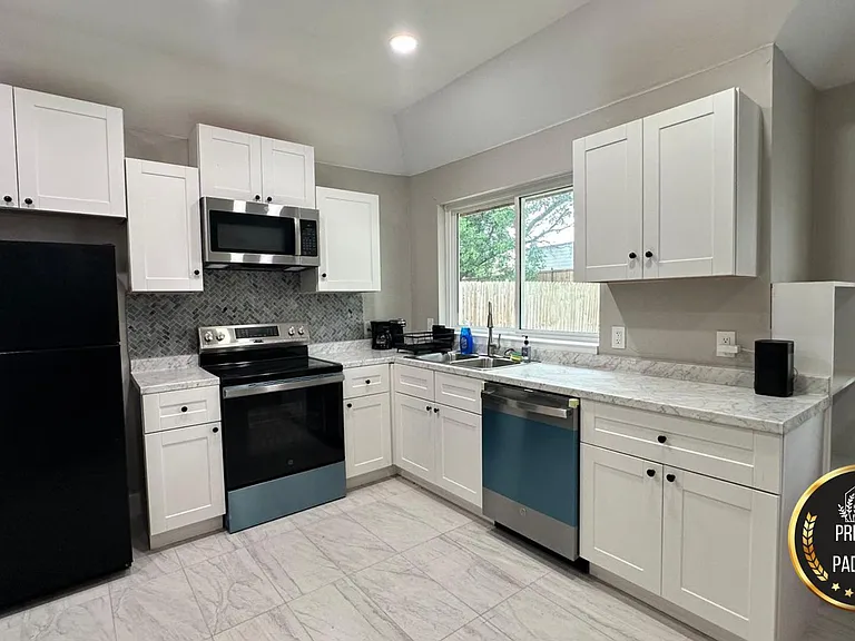 Updated kitchen with ample cabinetry, generous counter space, and stainless appliances including dishwasher and microwave.