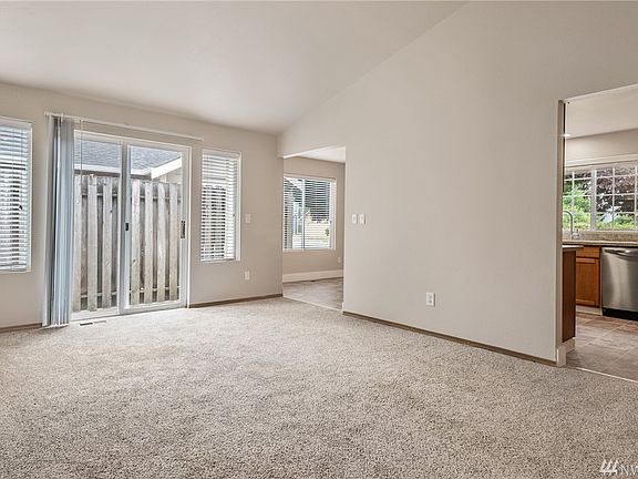 The living room, with new plush carpeting, provides access to the back patio.