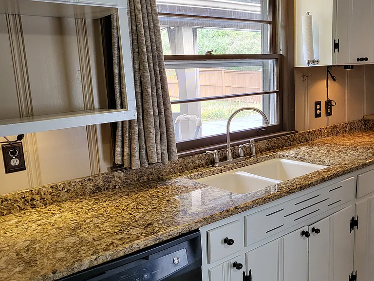 Freshly painted kitchen with granite countertop.