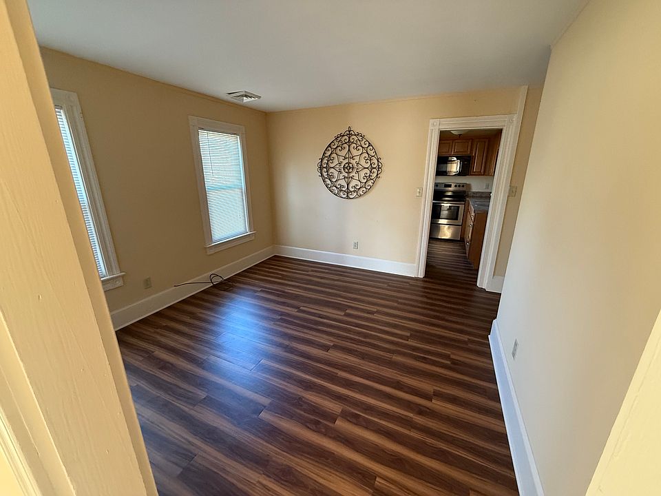 Large wood style vinyl plank Living room with access to galley style Kitchen
