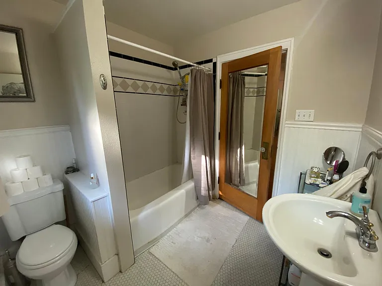 April 2025-Bathroom, pedestal sink, updated wall tile, original doors, full length mirror, beadboard walls