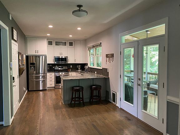 View of the kitchen and doors to the back porch. All stainless steel appliances and ample cabinet space. Entrance to the two-car garage is off from the kitchen.