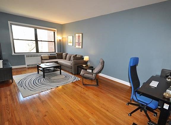 The large sunny, sunken living room has Eastern Exposures and refinished hardwood floors.
