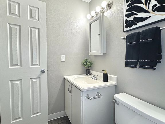 Sleek modern bathroom with a pristine bathtub, stylish vanity, and bright lighting.