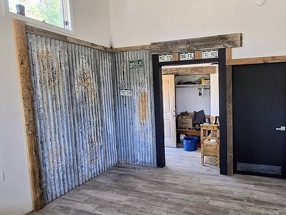 Rustic tin backed wall from old roof. Pot belly stove will be installed in corner