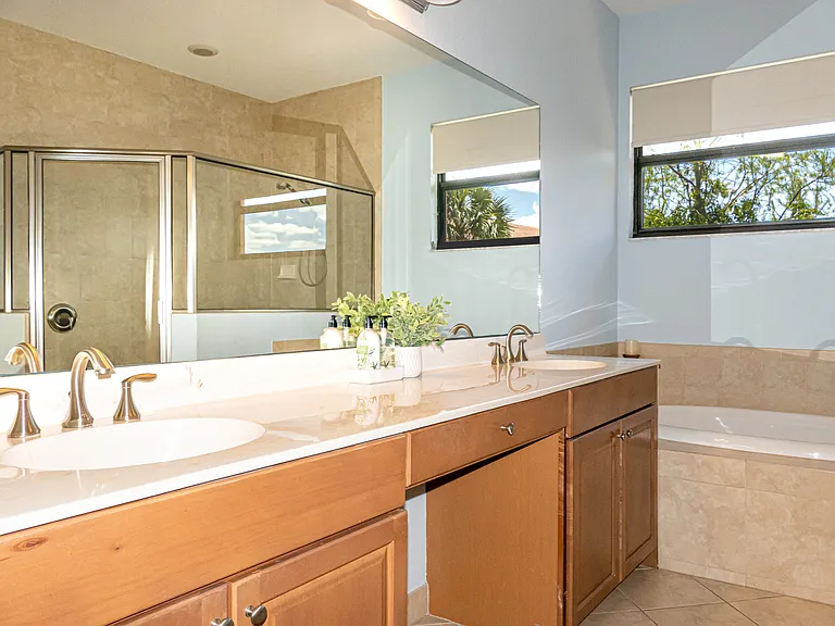 Master bathroom with tub. View of large shower with framed glass enclosure seen in mirror