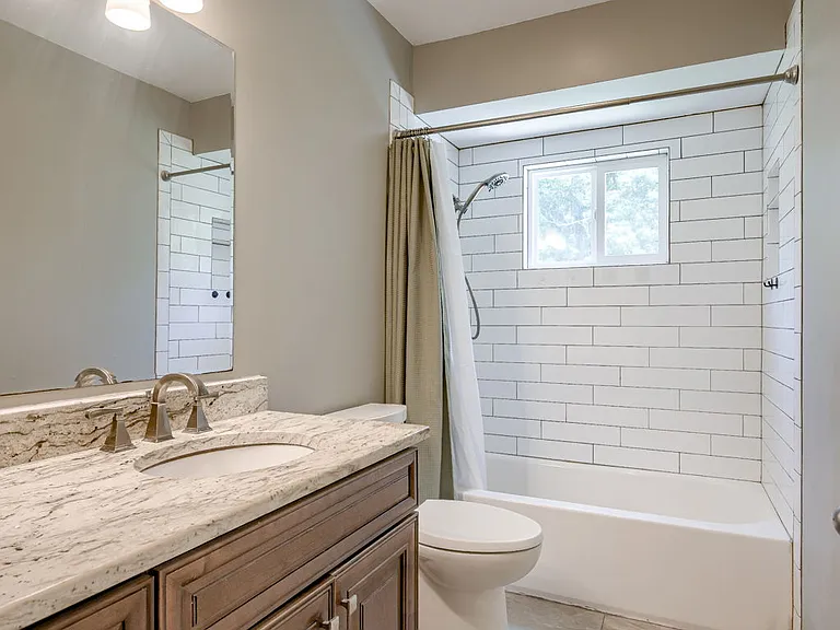 Bathroom1: Primary hall bathroom upstairs with nice tiled shower, flooring, and vanity + mirror and light fixtures