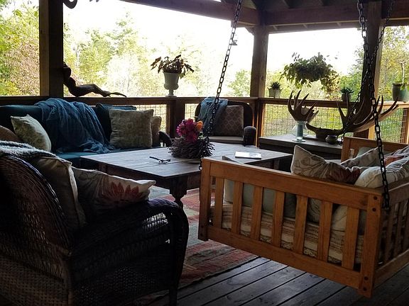 covered porch with swing bed and weatherproof furniture