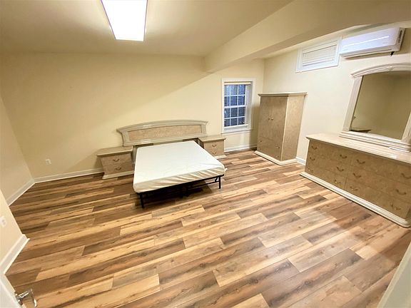 Bedroom with hardwood floor and partial furniture