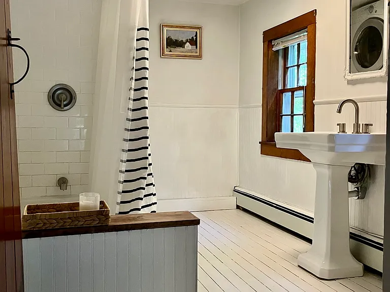 Updated farmhouse style bath with new tub, stackable washer/dryer, 2 windows