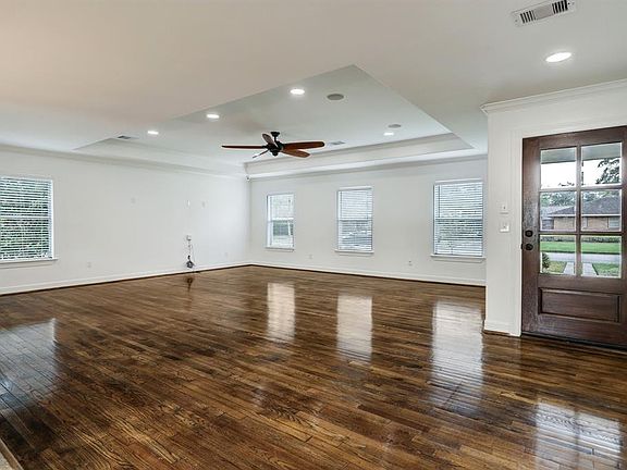 Huge open living room with recessed lights and raised tray ceiling.