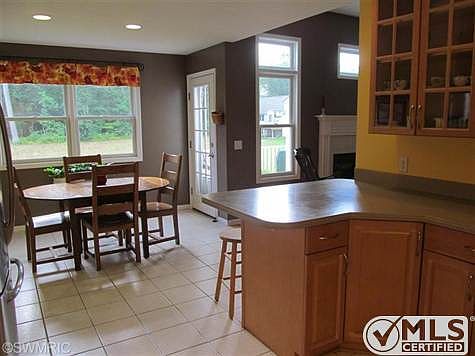 Large Kitchen with dining area, tile flooring, lots of counter space, many cabinets, door in far right of photo leads to the large deck and nice back yard.