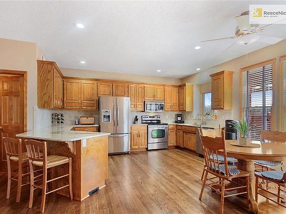 All the bells & whistles.....granite, eat-in bar, hardwood floors, ceramic backsplash,  cabinets aplenty.  Around the corner large pantry & Mud Room.  Open & inviting; lovely gathering & entertaining space.