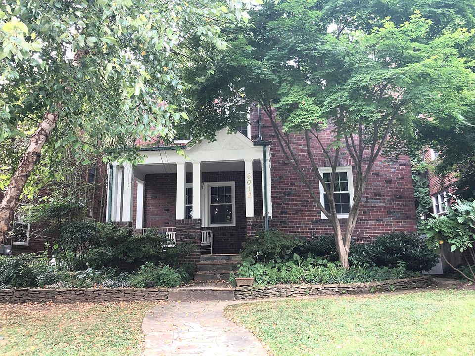Shaded Tudor-style large home.