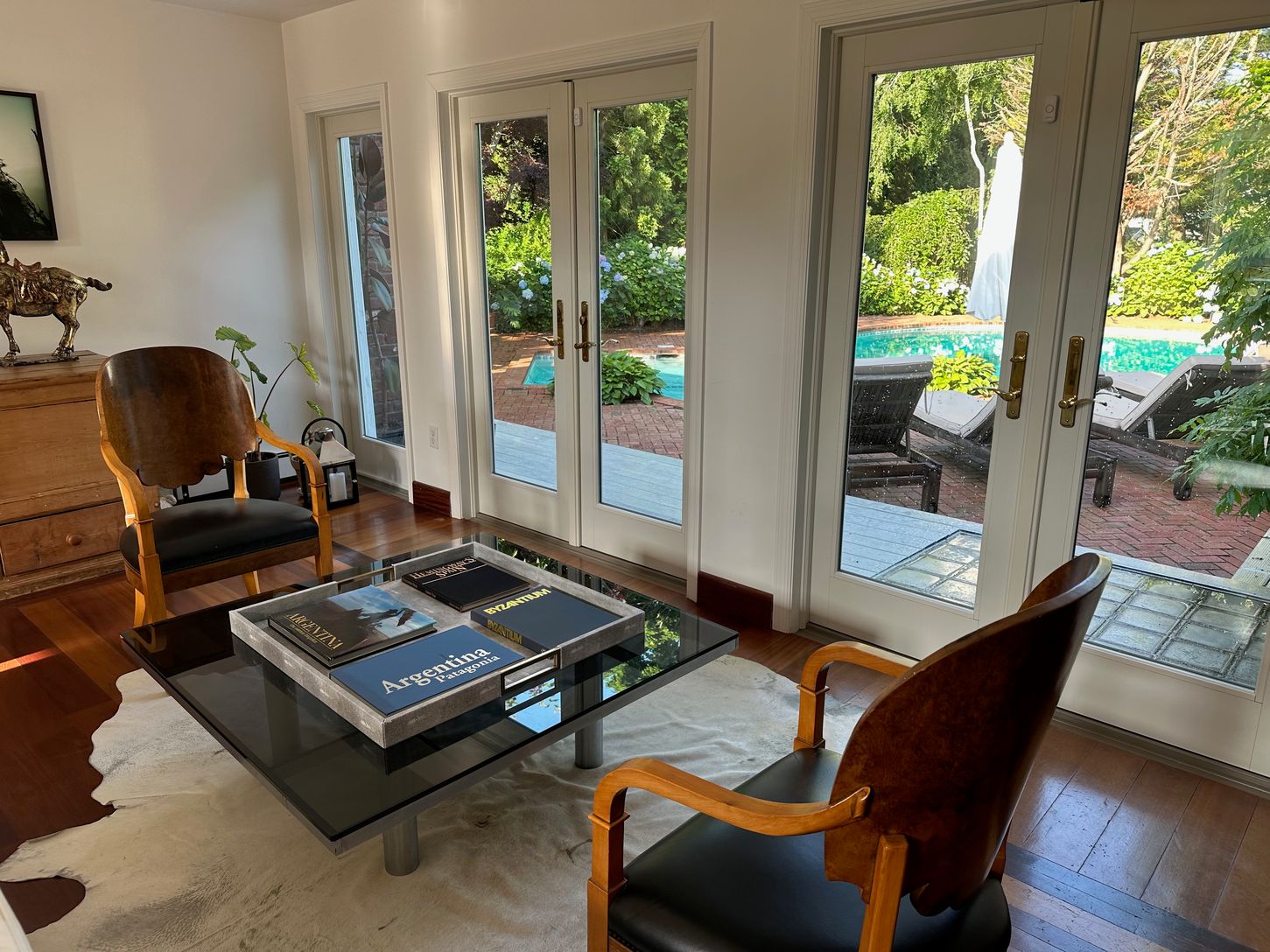  seating area overlooking pool, door closed in photo, next photo showcases doors open