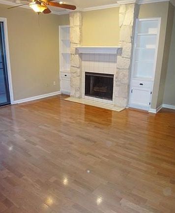 Living room with wood flooring, ceiling fan, built in storag