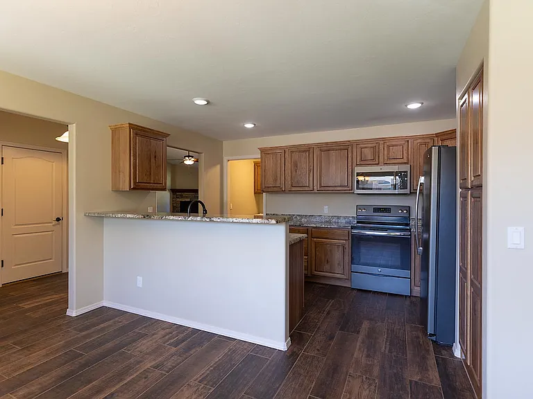 View of kitchen from dining room, maple cabinets, stainless steel appliances, granite countertops