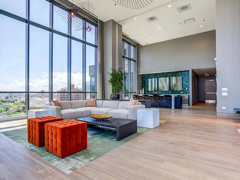 Take in the impressive views from the rooftop lounge, featuring soaring ceilings and tall windows that create an open, airy space filled with natural light.