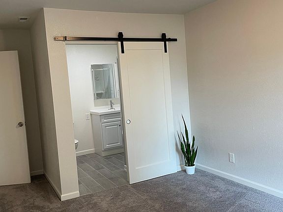 BR2 with attached 3/4 bath and open barn door.