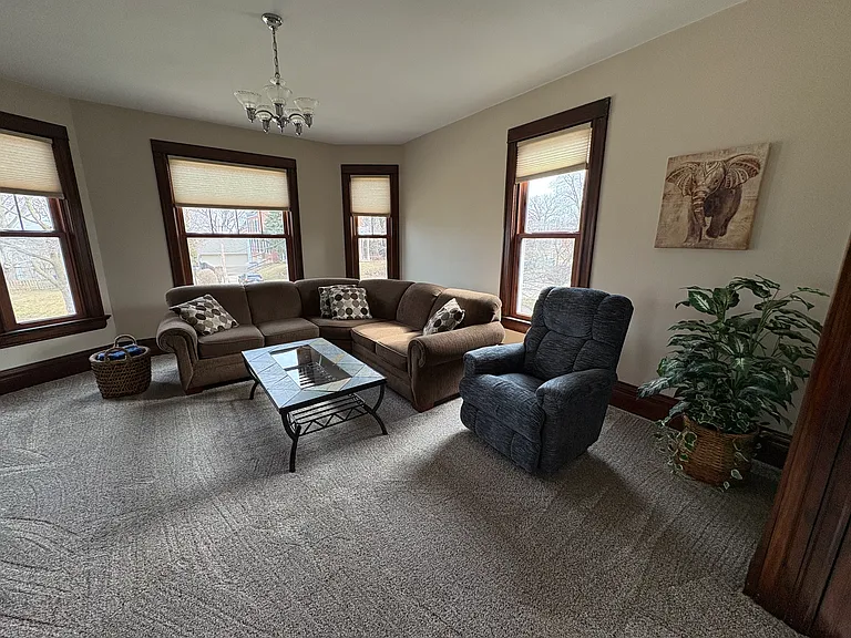 Living room furnished with brown sectional sofa and recliner.