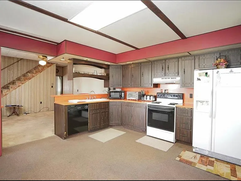 Large eat-in-kitchen has loads of storage and counter space, a dishwasher and all appliances included, and open to a large dining room with a breakfast bar