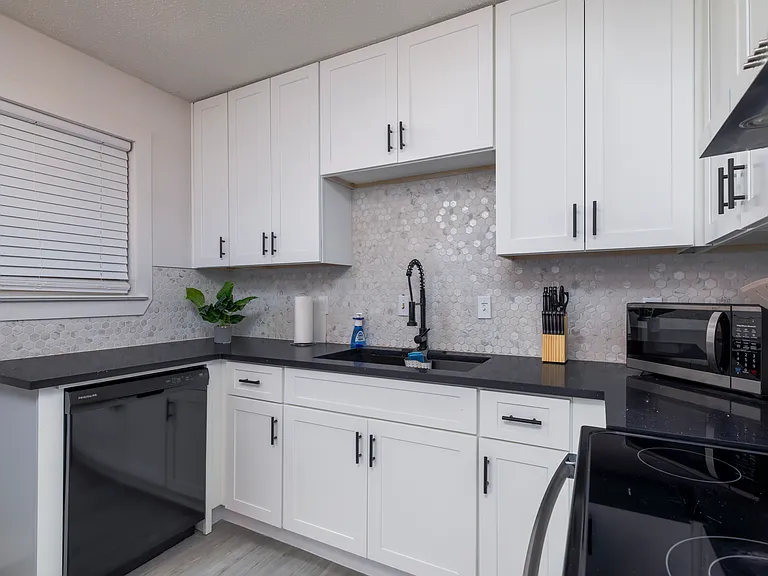 Fully stocked kitchen with a stainless steel range hood and cooking essentials