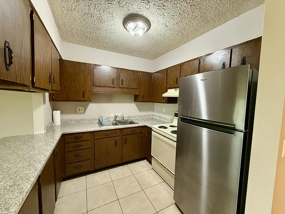Kitchen with tile flooring and new refrigerator