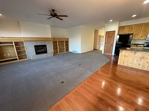 Living room area with a gas fireplace. There is new carpet in the entryway, and living area. All paint in the home is new. This is a good sized area for a couple couches. A stand with a flat screen tv was toward the back left corner previously and worked