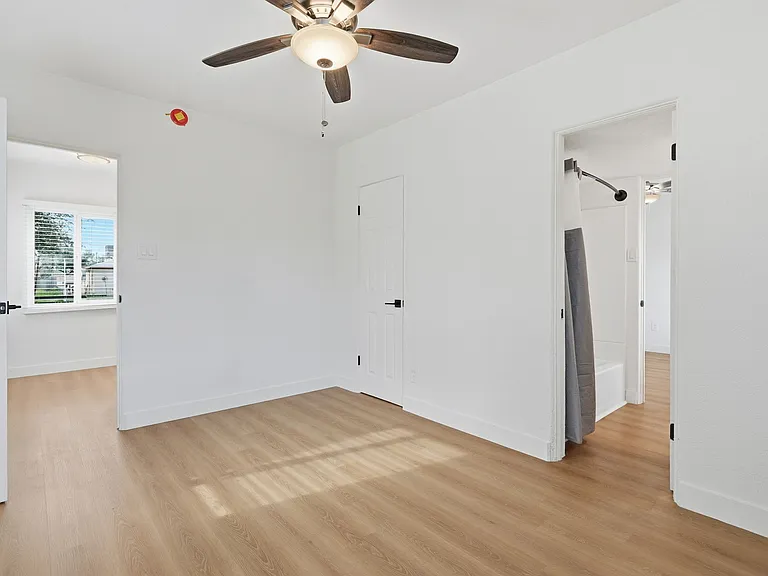 Bedroom 2 with shared bathroom and ding room visible. Light airy feel makes space feel cozy.