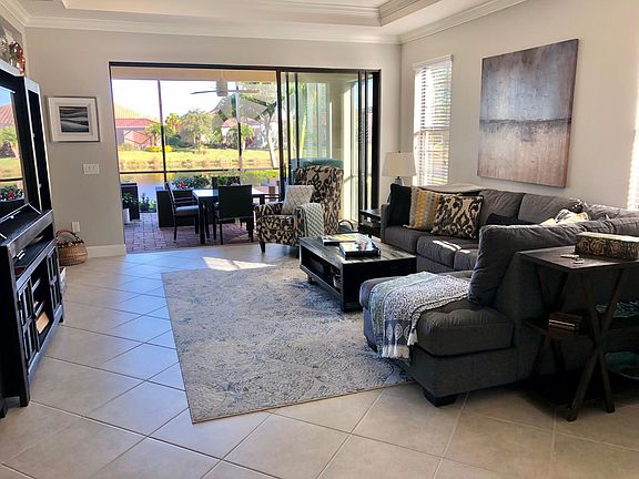 Living room with lake view behind screened patio and lanai. From entrance area. (You would also enjoy this view from the kitchen)