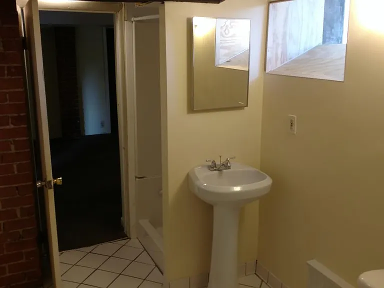 Shower stall is behind sink wall