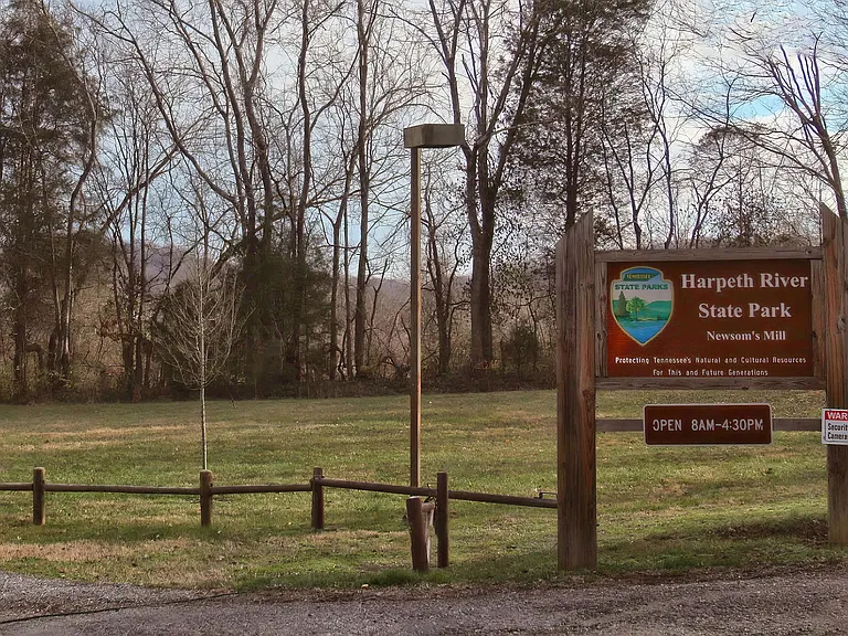 Entrance to Harpeth River State Park with Scenic Tree Line and Signage