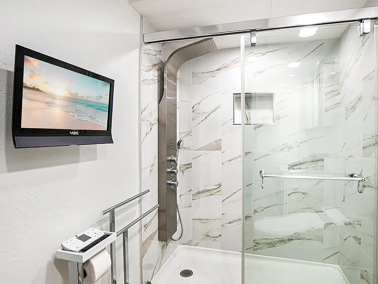 Bathroom featuring walk-in shower with 3 spray-zone shower panel and Alexa-compatible TV.