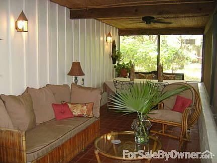 Outdoor Living Area : Screened living and dining space with ceiling fans and terra cotta tile floor