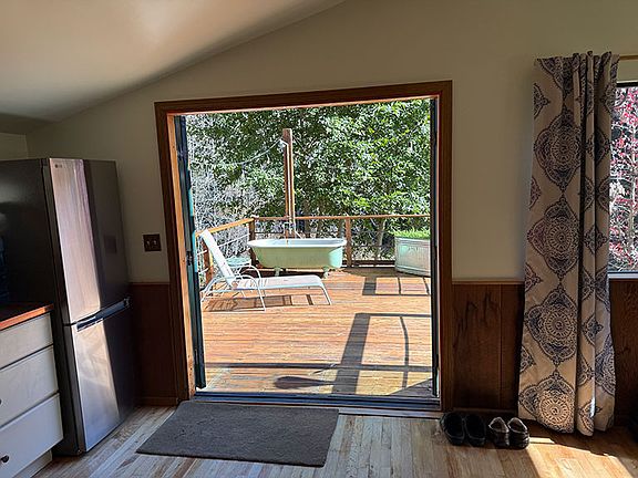 Private deck with clawfoot tub & shower from inside kitchen looking out French doors