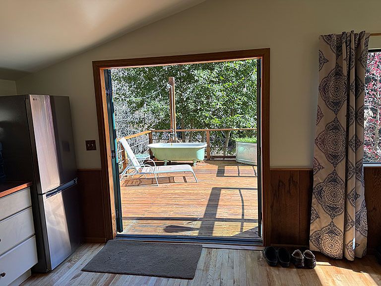 Private deck with clawfoot tub & shower from inside kitchen looking out French doors