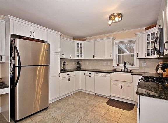 The eat-in kitchen is both attractive and highly functional,with granite counter tops, farm sink, ti