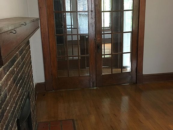 Living Room hardwood floors and fire place toward French Doors and Second Bedroom/Office/ or Dining Room area.