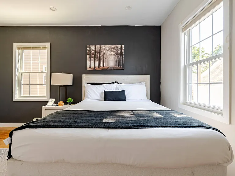 Well-appointed bedroom with a comfortable bed, bedside lighting, and large windows for natural light and outdoor views.