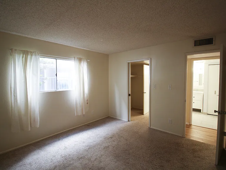 View of master bedroom connecting to walk-in closet and hallway