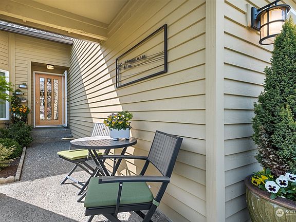 Gorgeous wood front door. Lovely covered seating area overlooking the enchanting gardens is a perfect place to start your day with a morning cup of coffee.>