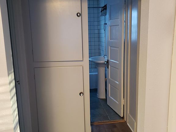 Hallway leading to the bathroom and bedrooms. There are 4 large storage areas in the hallway as well as an overhead shelf for storage.